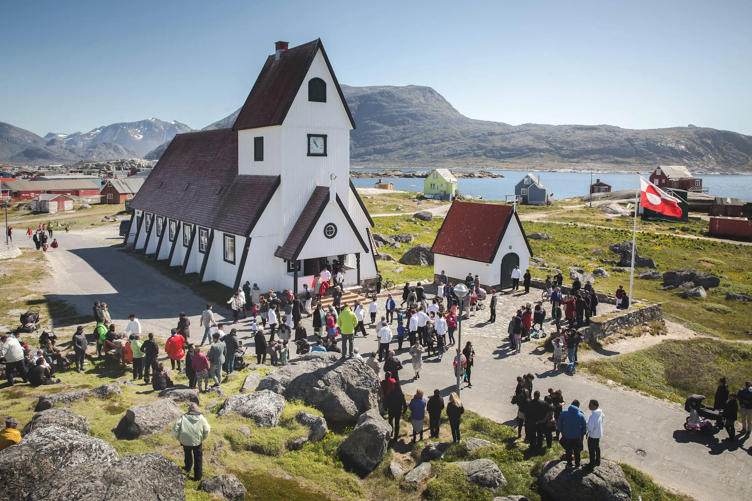a-large-crowd-of-people-gathered-at-the-church-in-nanortalik-in-south-greenland-1.webp