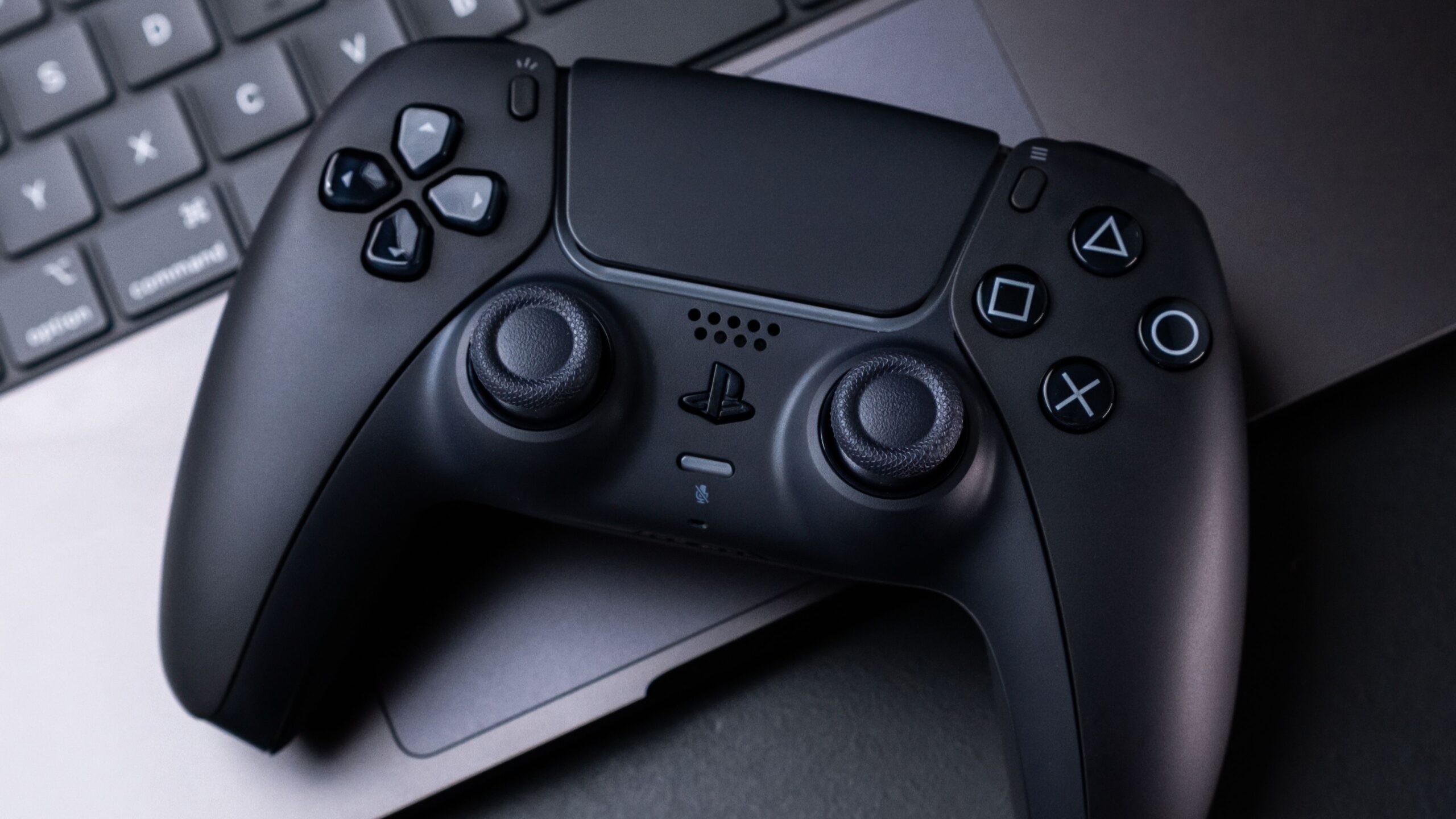 a-black-playstation-5-dualsense-controller-on-a-macbook-scaled.jpg