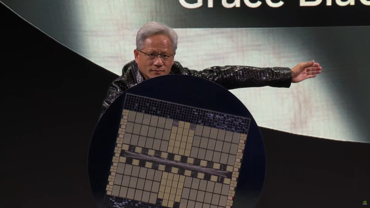 Sahnedeki konuşmacı büyük bir NVIDIA çipini gösteriyor; arkada ekranda Grace yazısı.