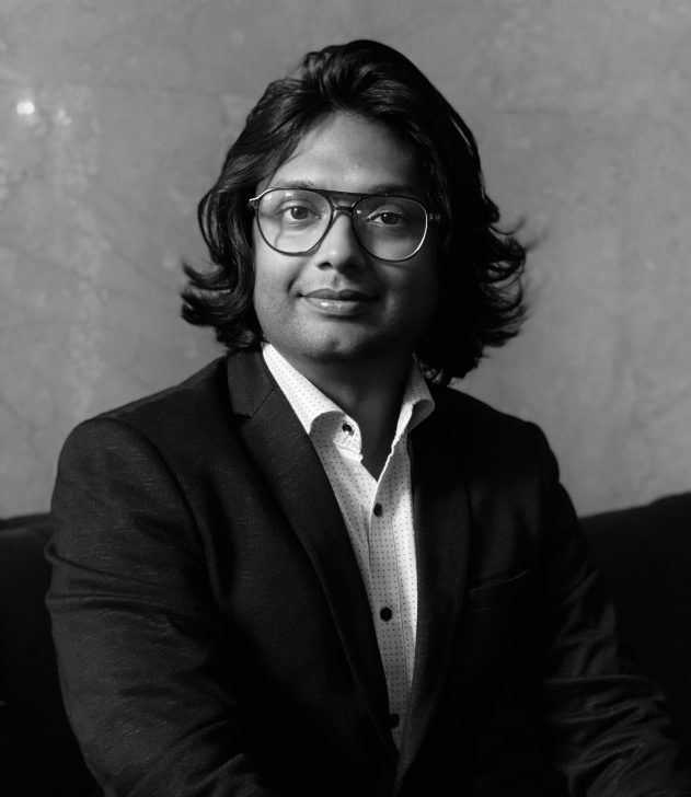 Unbranded person in a suit against a stone wall background.