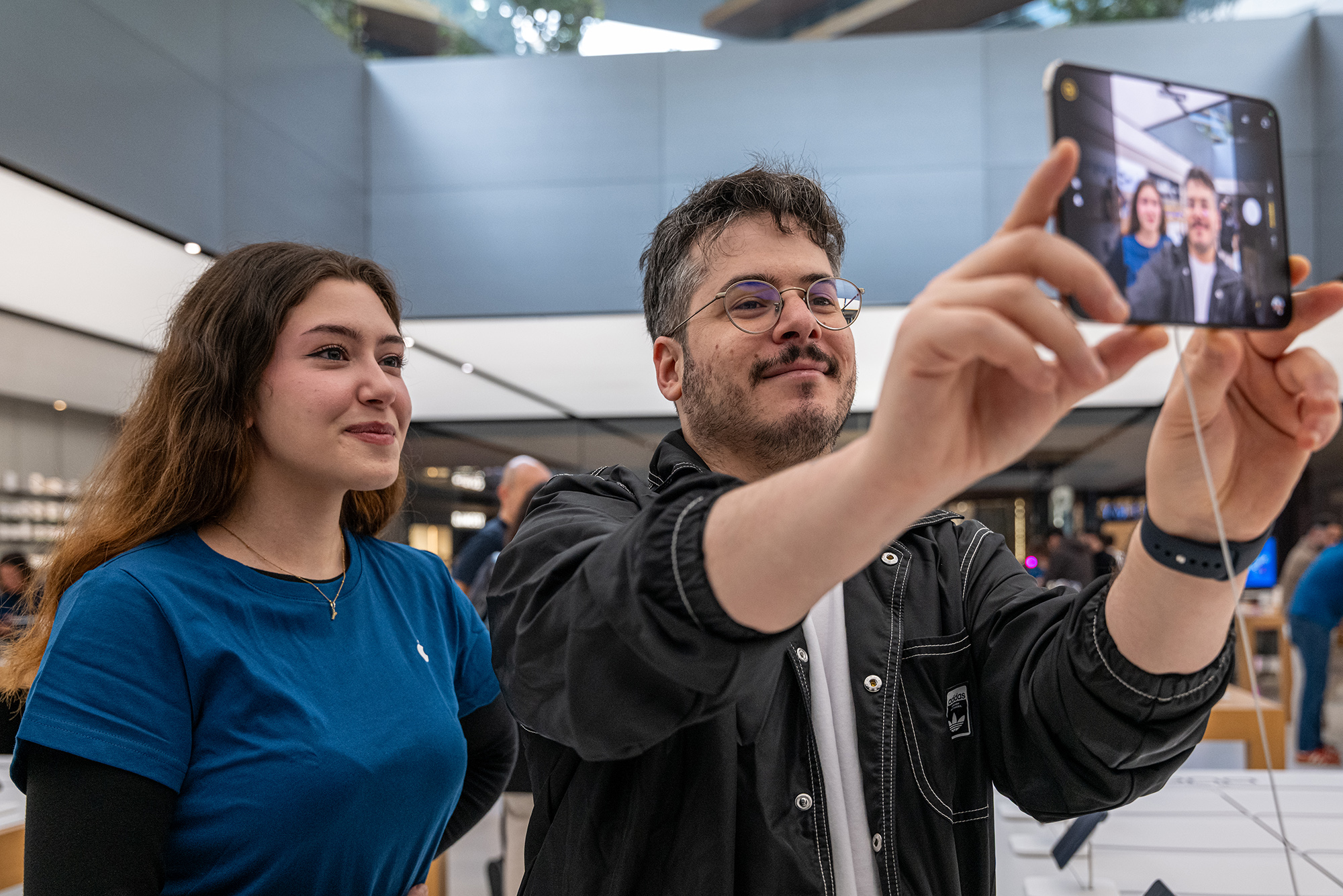 Arman Güvenç, Apple Zorlu mağazasında iPhone Duo’yu denerken